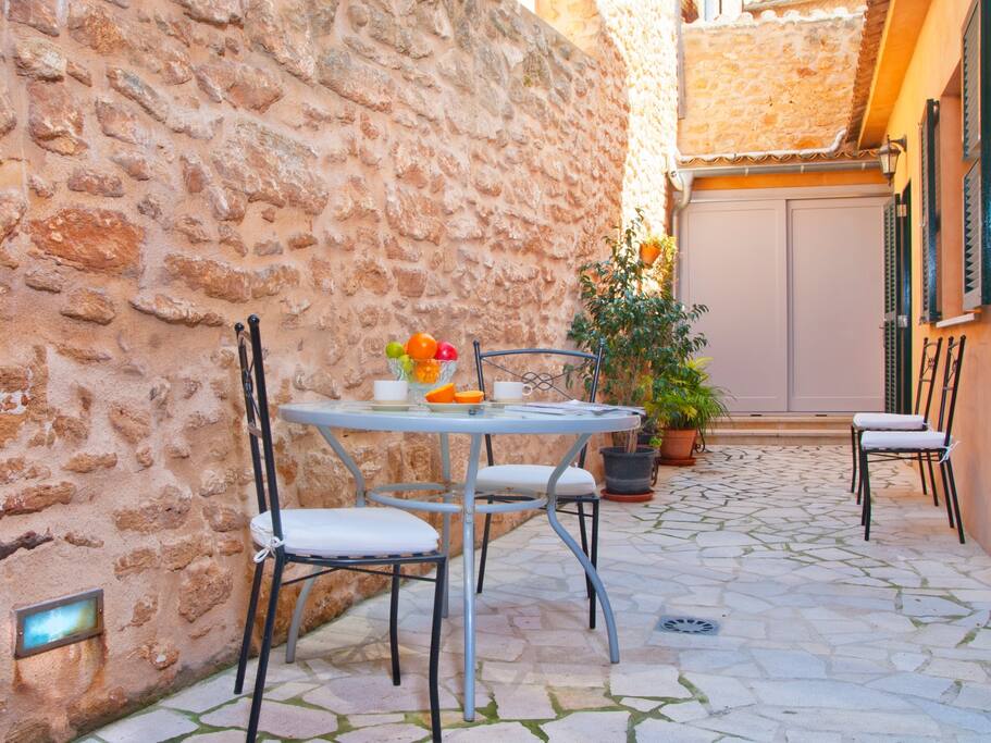 Zona de desayuno en el patio con mesa, sillas y hamacas
