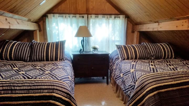 Roshani ya kulala yenye vitanda viwili vya ukubwa kamili na sehemu ya dirisha ya AC.