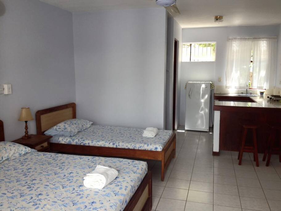 Room with kitchenette and ceiling fan, steps from the beach!