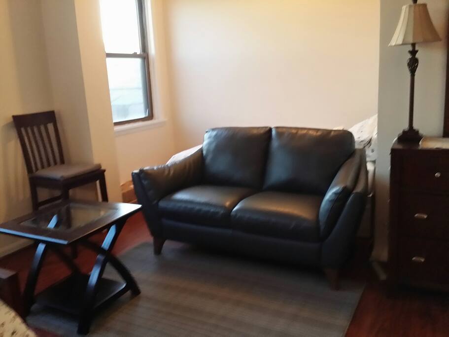 Twin bed behind this leather sofa