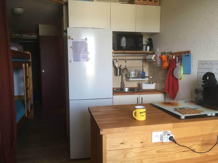 Le coin cuisine combiné réfrigérateur-congélateur, le micro-ondes et la cafetière à dosette