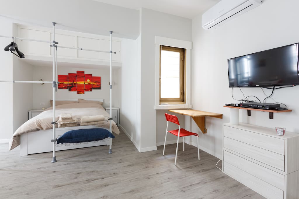 Zona letto con tavolo pieghevole e tv