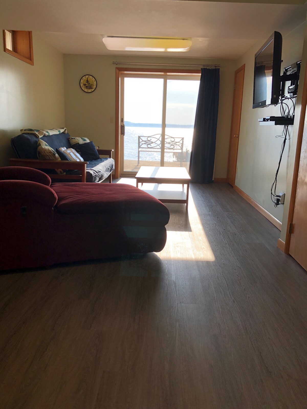 غرفة معيشة منخفضة المستوى مع أريكة فوتون ومن الباب إلى السطح. فبراير 2020 سيتم استبدال فوتون بسرير أريكة بحجم كوين.