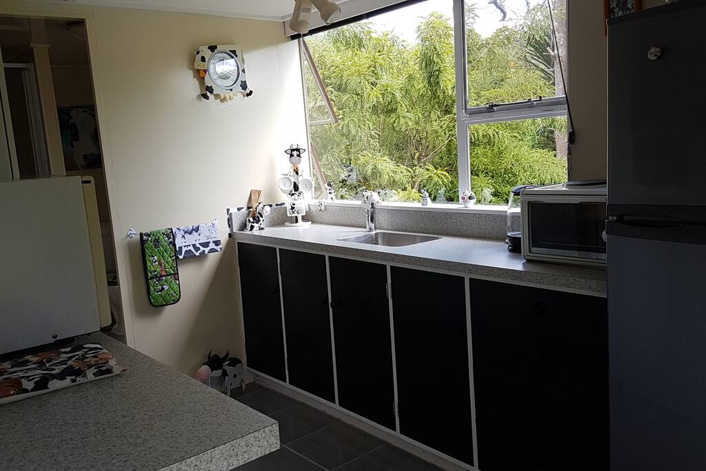 A fully equipped kitchen with a bench-top oven and hob, a fridge/freezer, microwave oven and toaster.