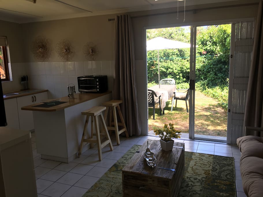 Open plan TV & Kitchen area with ceiling fan.