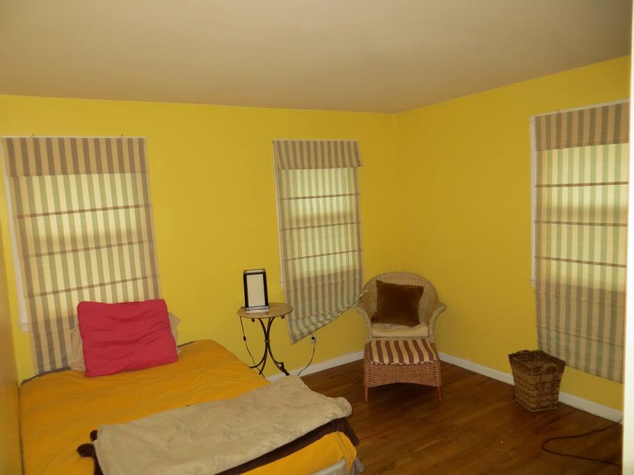 The bedroom has a closet with a dresser. There is plenty of light from the 3 windows when the shades are drawn.