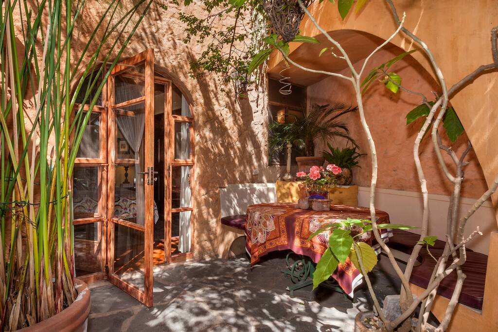 Entrance to casita; outdoor dining and banquette with organic kumquat and pomegranate trees.