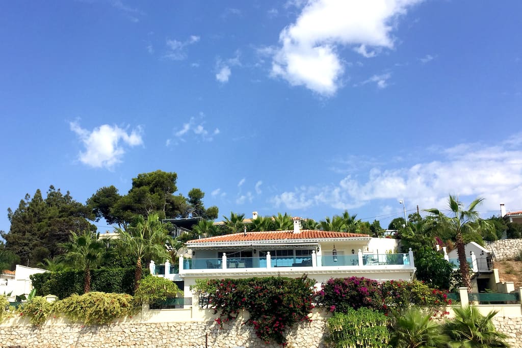 The villa is distributed over two floors and surrounded by gardens and terraces.