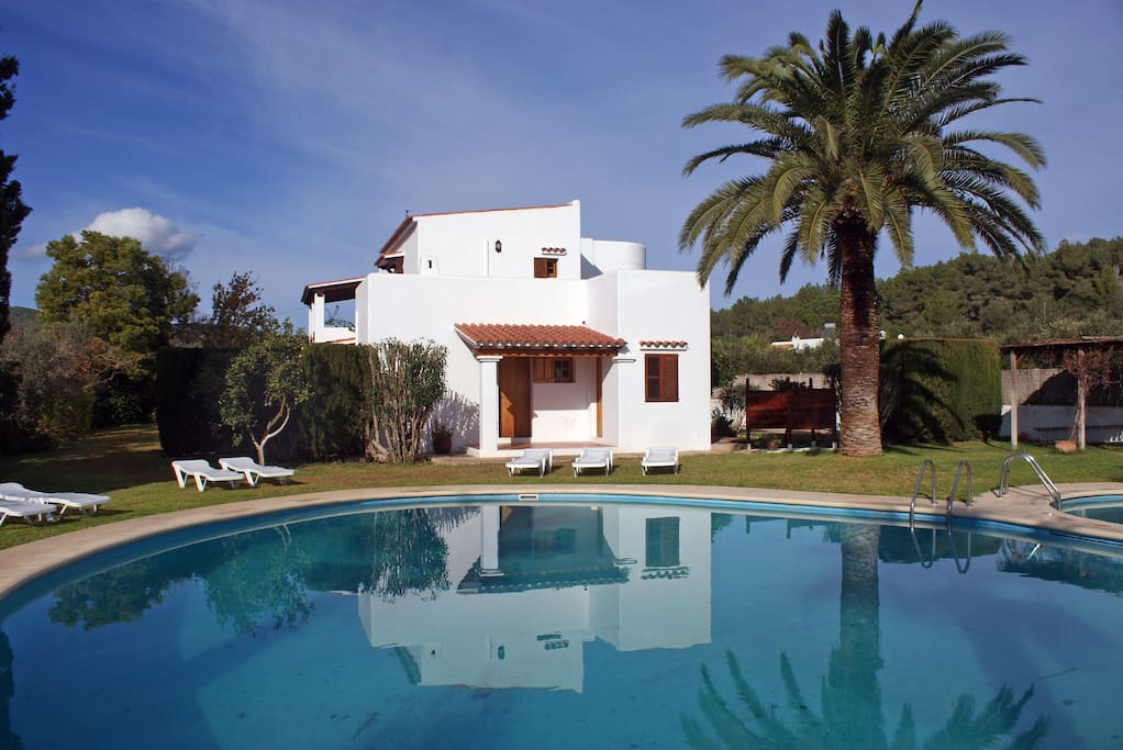 View of the green and sunny garden with the pools