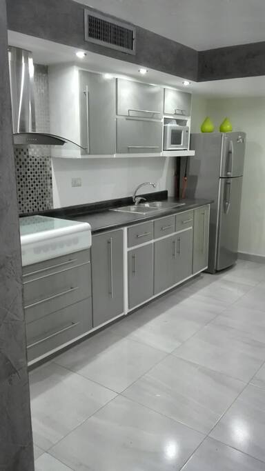 cocina equipada con electrodomésticos y utensilios