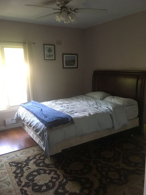 Queen size bed with desk and full bathroom.