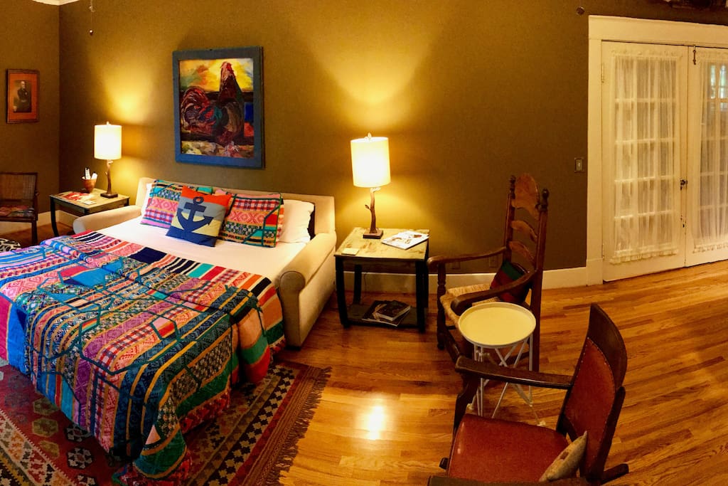 Sleeping area at one end of room; entry, sitting area and desk at other end