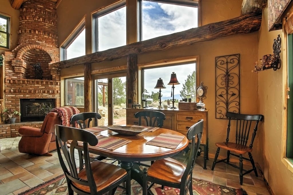 This gorgeous custom built log home features tall ceilings, floor to ceiling windows, and natural wooden beams.