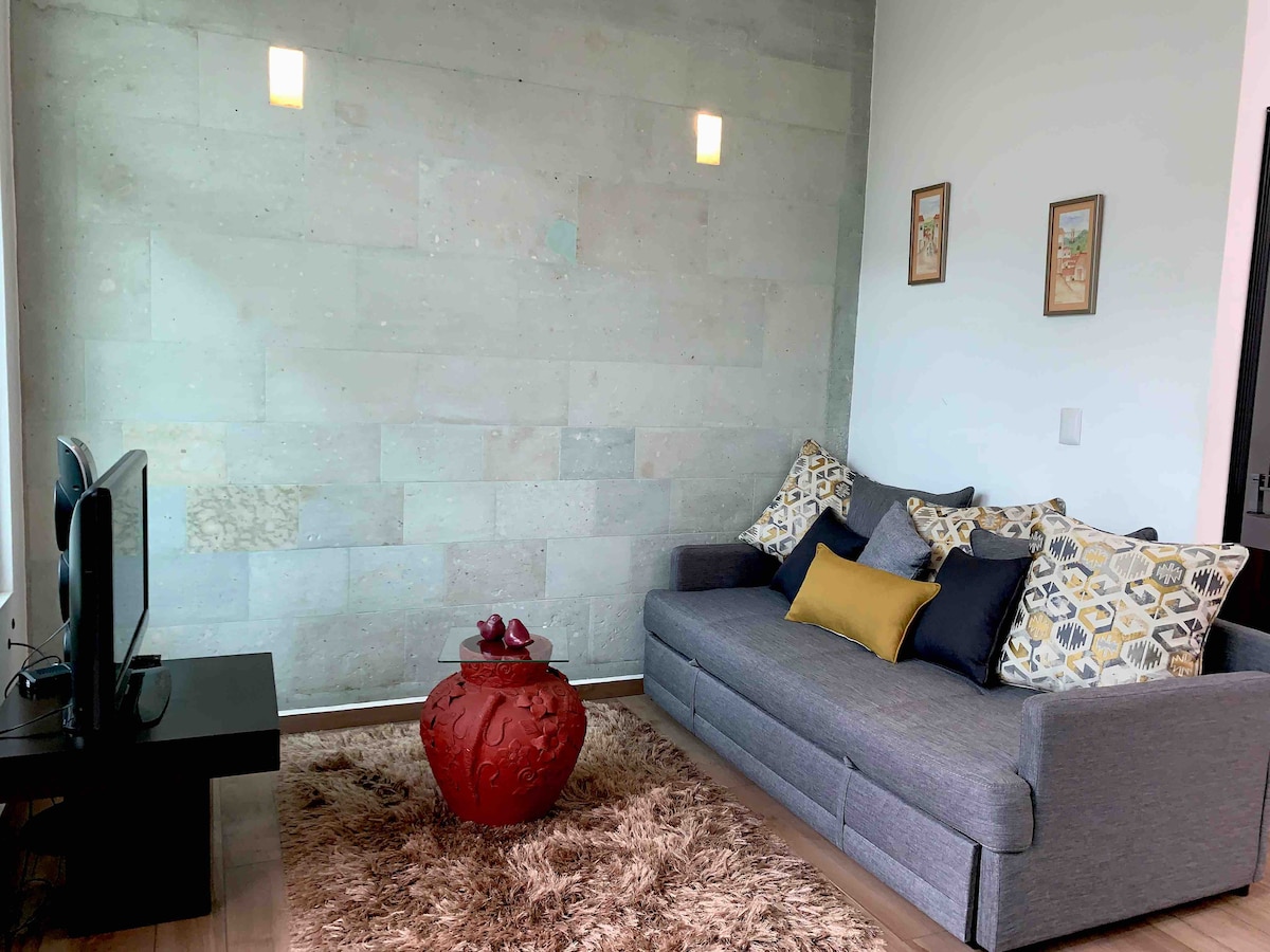 Sala de estar con sofá cama y  TV 