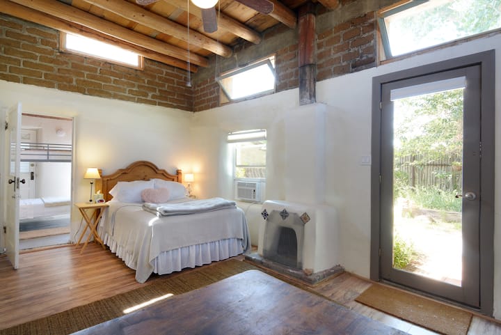 La chambre de l'Hacienda Cielo est entourée de fenêtres qui sont éclairées par le plafond original de lattie et de viga. Nous avons remplacé le lit double par un lit queen.