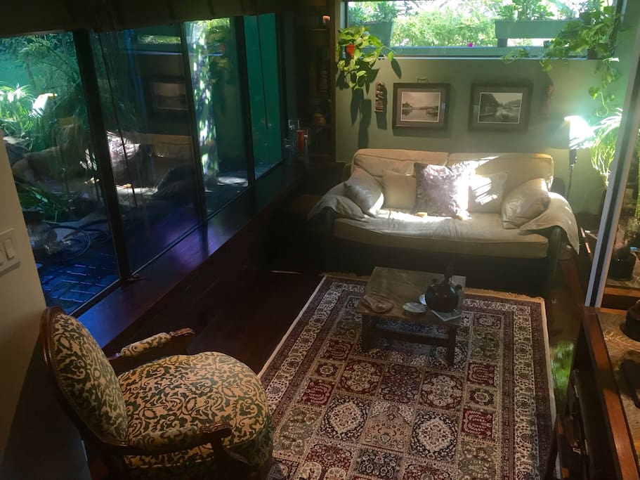 The living room looks out to the private courtyard and pond with the sounds of the waterfall creating a relaxing tranquility.