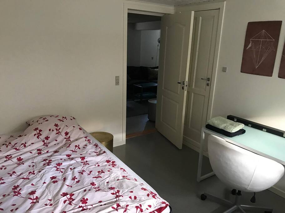 Lyst Soveværelse med dobbeltseng. Skrivebord hvor du har mulighed for at sidde og arbejde.