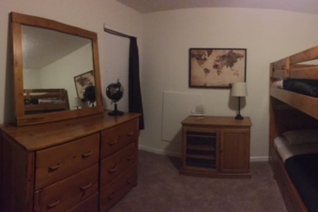 One bedroom with twin bunk beds with plenty of storage space in the dresser.