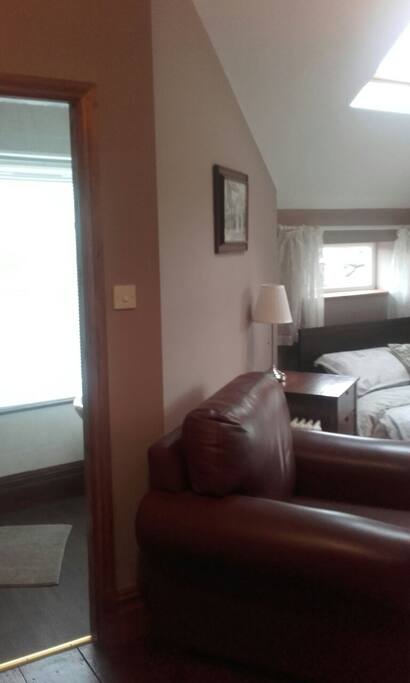 large relaxing armchair leadin to en-suite
