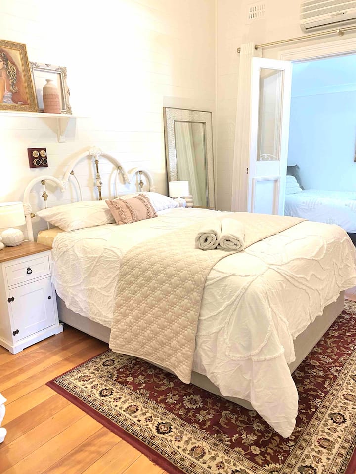 Dormitorio 4 con aire acondicionado de ciclo inverso, cama tamaño queen, puertas francesas que se abren a la quinta habitación con 2 camas individuales. No hay TV en esta habitación.