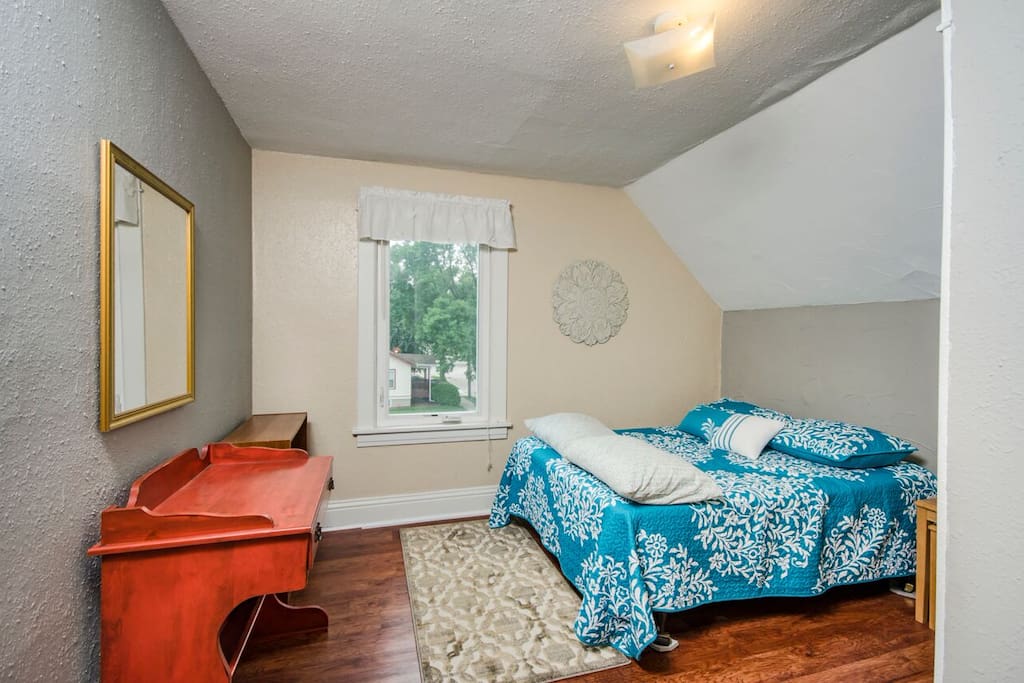 Bedroom- full-size bed, writing desk, and open-shelving (closet not pictured)