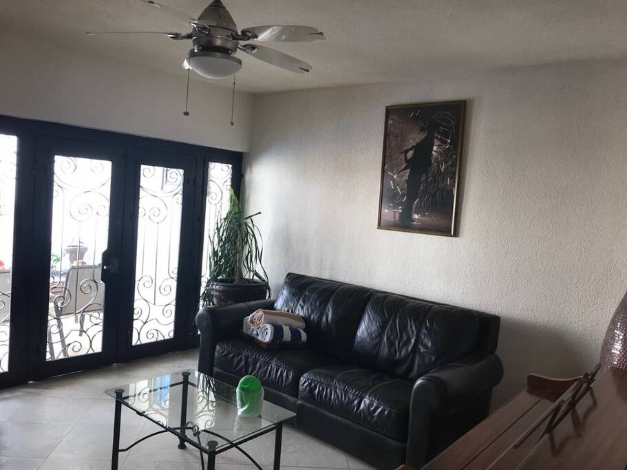 Sala de TV con salida directa a la alberca y estancia exterior.