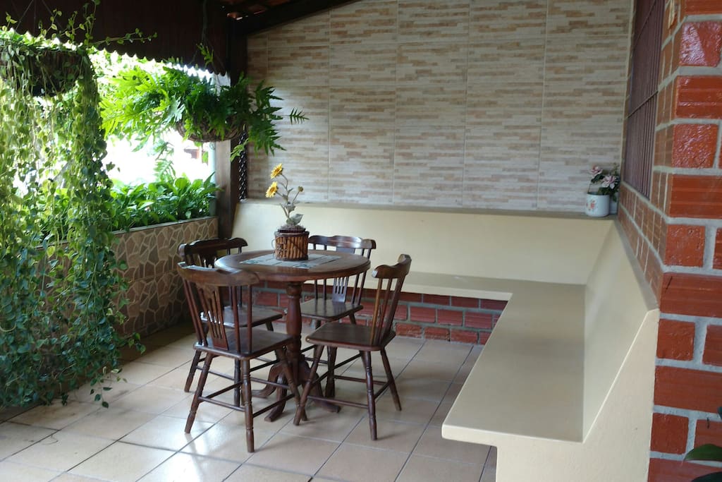 Terraço em L com uma mesa para jogos ou para curtir o friozinho com quatro cadeiras.
