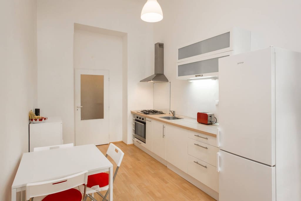 Kitchen with a table with four chairs (one stored behind the cupboard)