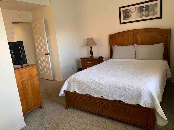 Veľká manželská posteľ a televízor v spálni. 