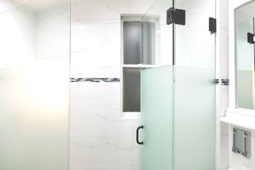 Enjoy the most luxurious shower you've ever taken underneath the best rain shower head in the industry inside a custom-tiled frosted glass-enclosed shower