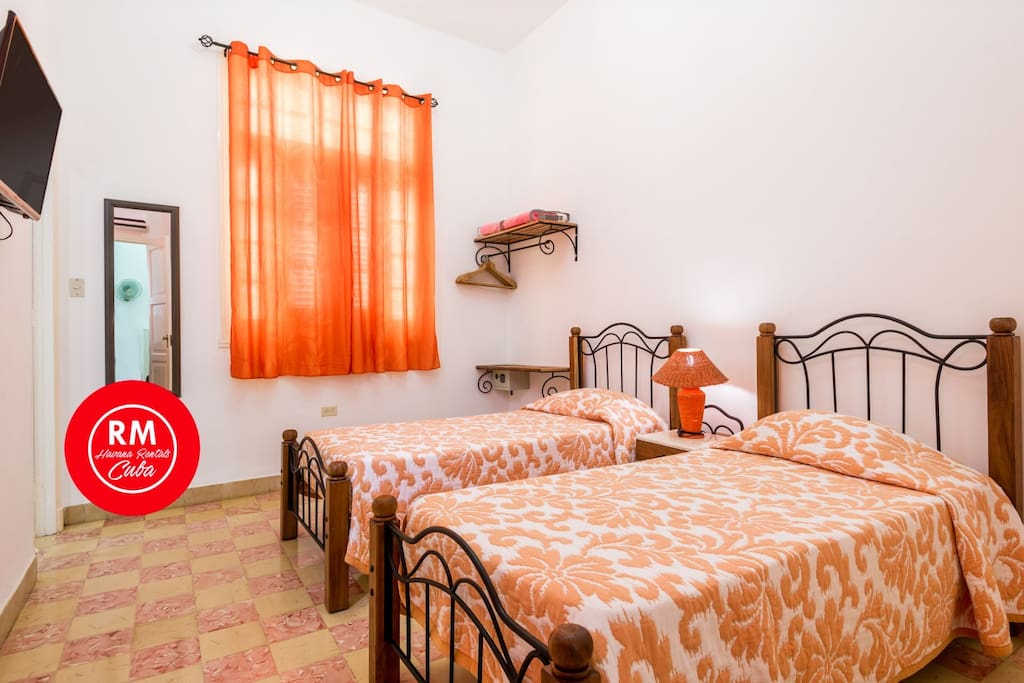 bedroom with air conditioner device tv and bathroom bathroom door by the left