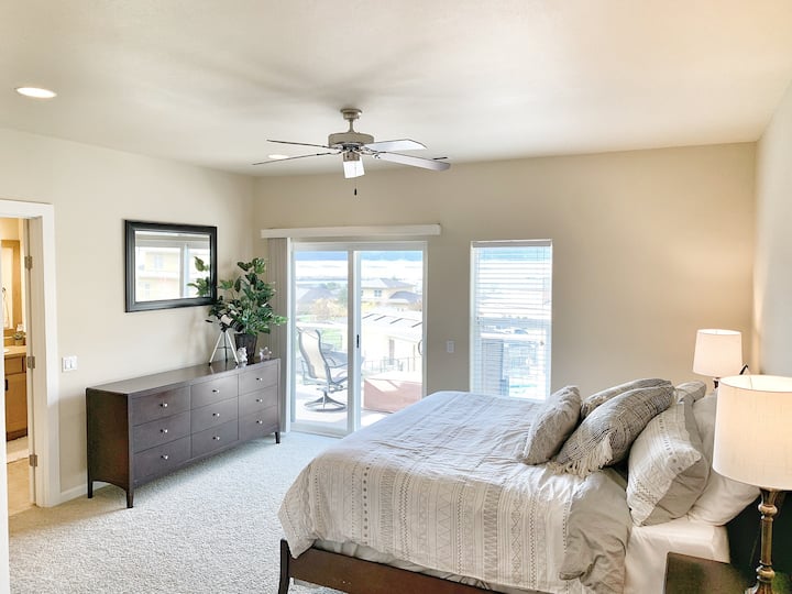 Dhomë gjumi kryesore me krevat "King Size" dhe hyrje në verandën e sipërme dhe dy karrige të rehatshme me tavolinë të vogël në natyrë