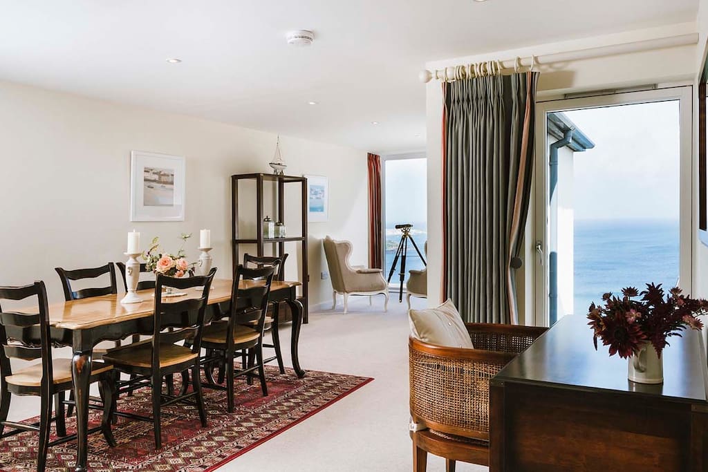 Large dining table with space for 6 (perfect for family meals) leading to Captain's Chair with telescope and sea views