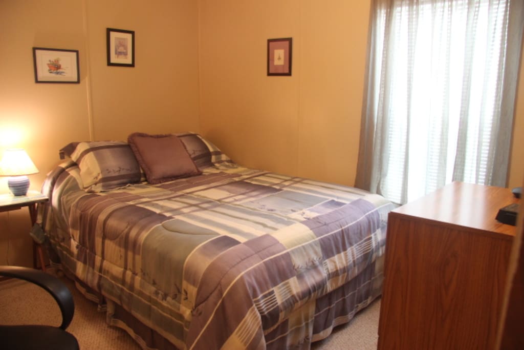 Queen size bed in front bedroom with dresser and nite stand.