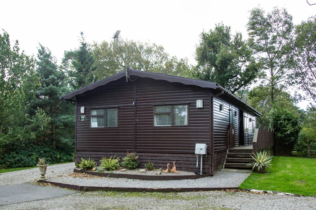 Front view of Tree Tops Lodge, with parking for two to the left hand side.