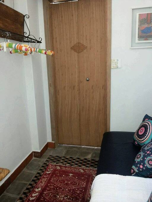 Vista de dentro do quarto com a porta da varanda fechada e o sofá cama fechado