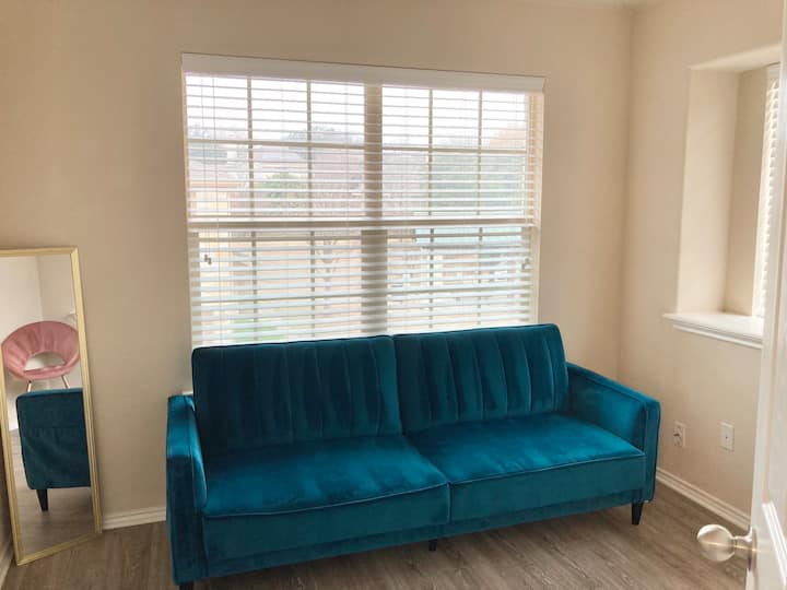 Zyrë në shtëpi ose dhomë hobi me divan modern prej kadifeje që mund të konvertohet në një krevat ditor