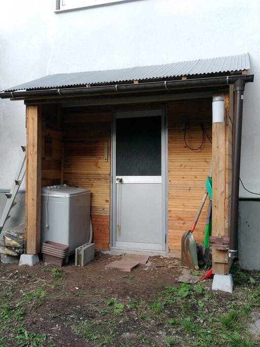 勝手口を改装しました。
施錠できますのでお荷物を置いておいても安心です。
中の全自動洗濯機が不調の場合は、ここにある二槽式洗濯機をお使いください。
中にある道具類は個人所有のものですのでお使いにならないでください。また、ここだけはゲスト様ご滞在中もオーナーが立ち入ることがありますので、それが不都合な場合は中にある扉を施錠しておいてください。