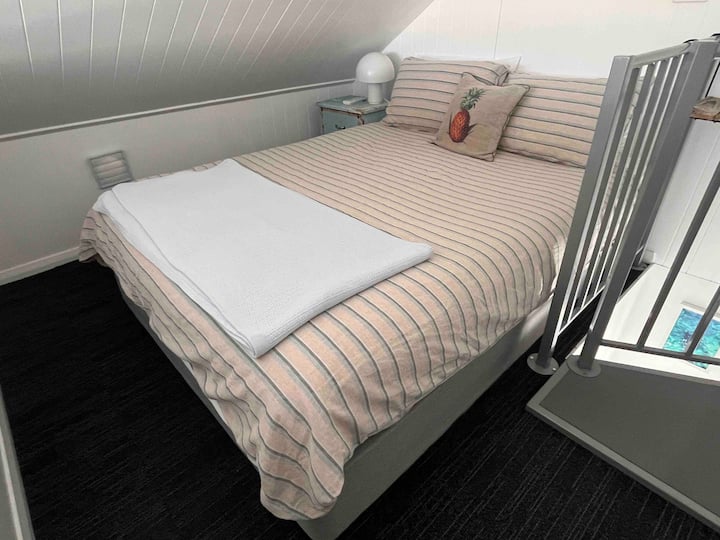 Manželská posteľ na poschodí. V tomto priestore je na stene klimatizácia s rozdeleným systémom. 