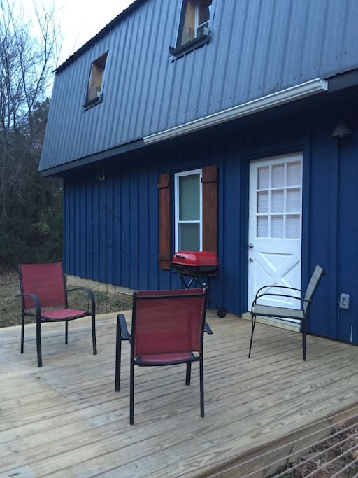 Outside deck with charcoal grill and seating area.