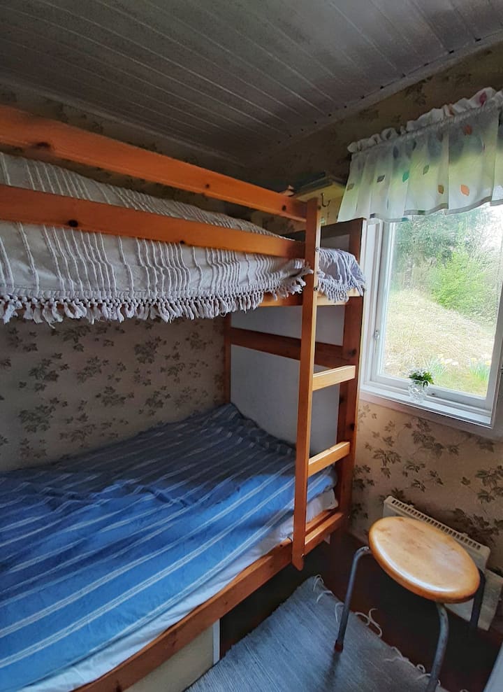 Cama de dormir com janelas para gramado, campos e floresta.