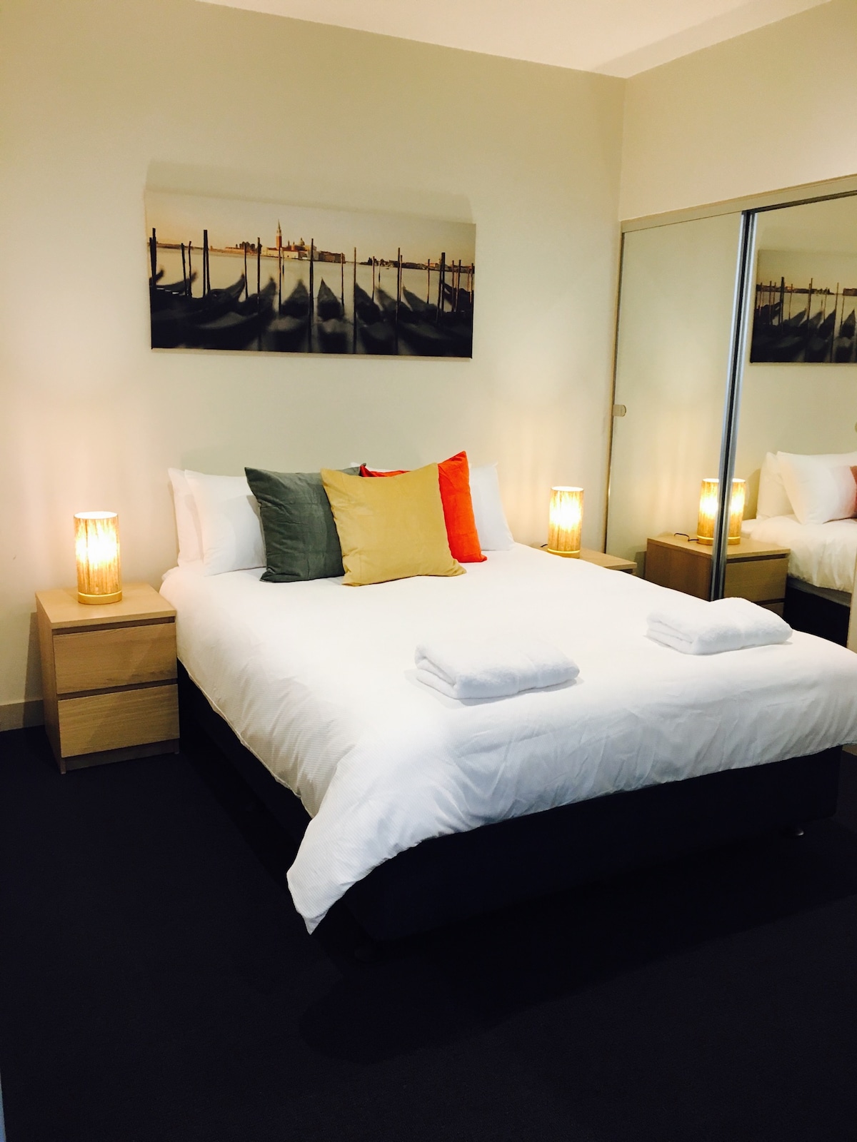 Главна спалня с двойно легло, огледален гардероб и директен достъп до банята.