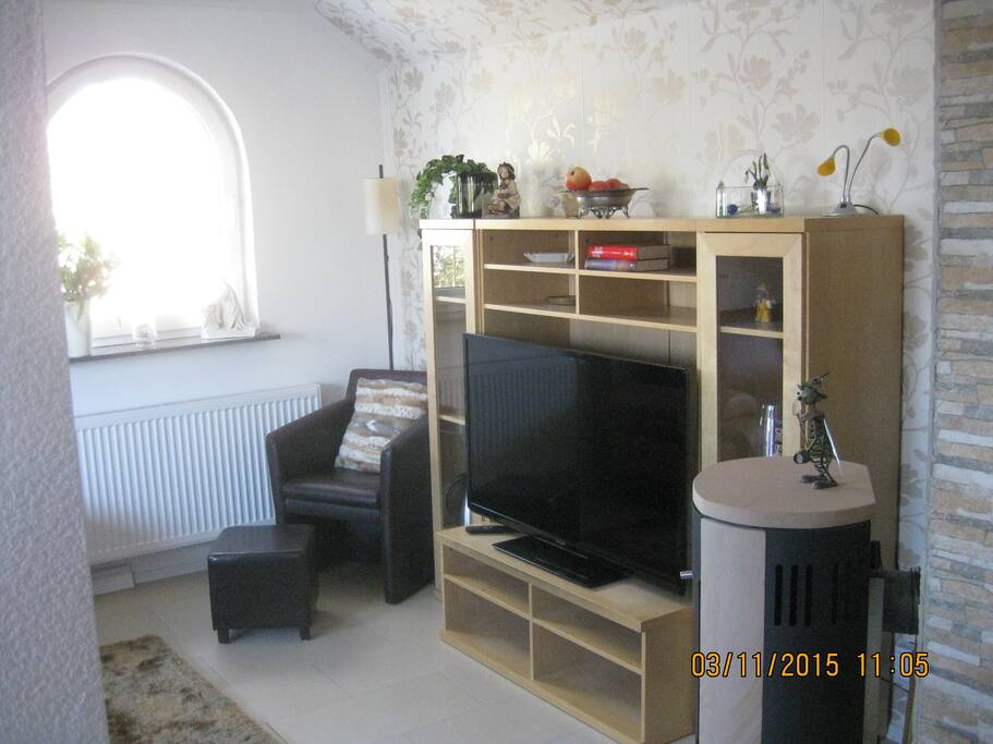 Wohnbereich mit Fernseher und Ofen