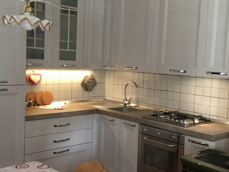 La cucina con forno, frigo e piano cocttura