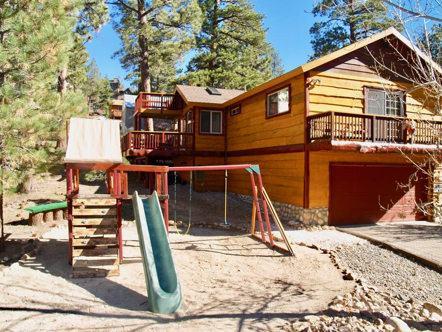 The playground has 2 swings, a slide, and a fort with a climbing wall.