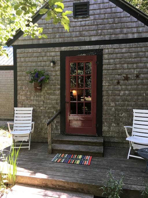 cabin is on the edge of an orchard, shaded by mature apple trees, tucked into the wood's edge