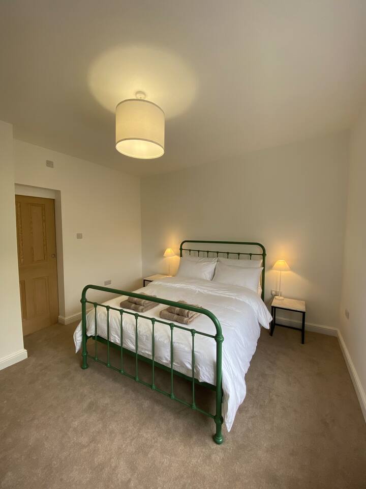 Chumba cha kulala 1: Sakafu ya chini. Kitanda cha Kingsize. Luxury sateen bedlinen, uchaguzi wa manyoya na mito ya sintetiki na kipofu mwenye giza ili kuhakikisha usingizi mzuri wa usiku! Samani za kujumuisha meza za kando ya kitanda, kifua cha droo, sehemu ya kuning 'inia na kioo cha urefu kamili.