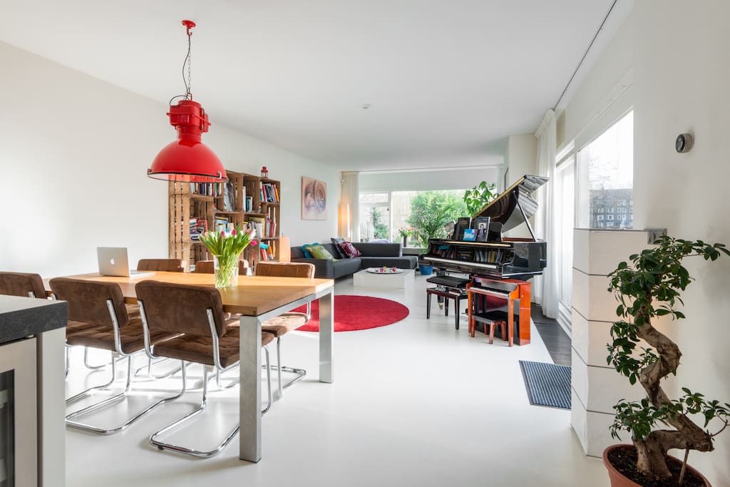 Living with grand piano and slide doors into garden