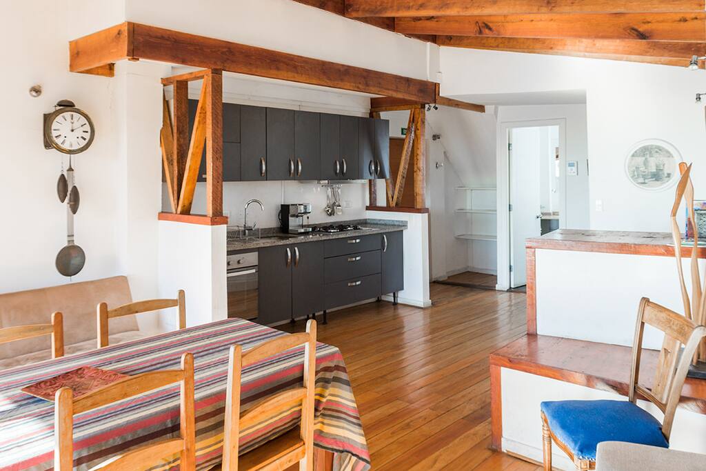 Bright and ample living room with open space kitchen and dining table