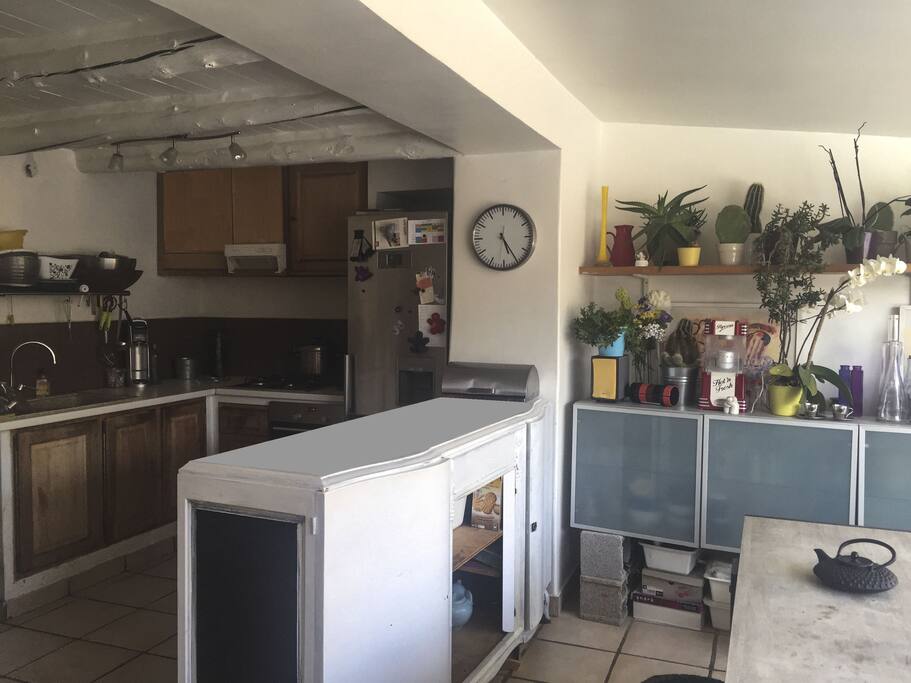 La cuisine. Une table pour 10 couverts longe la baie vitrée donnant sur la piscine